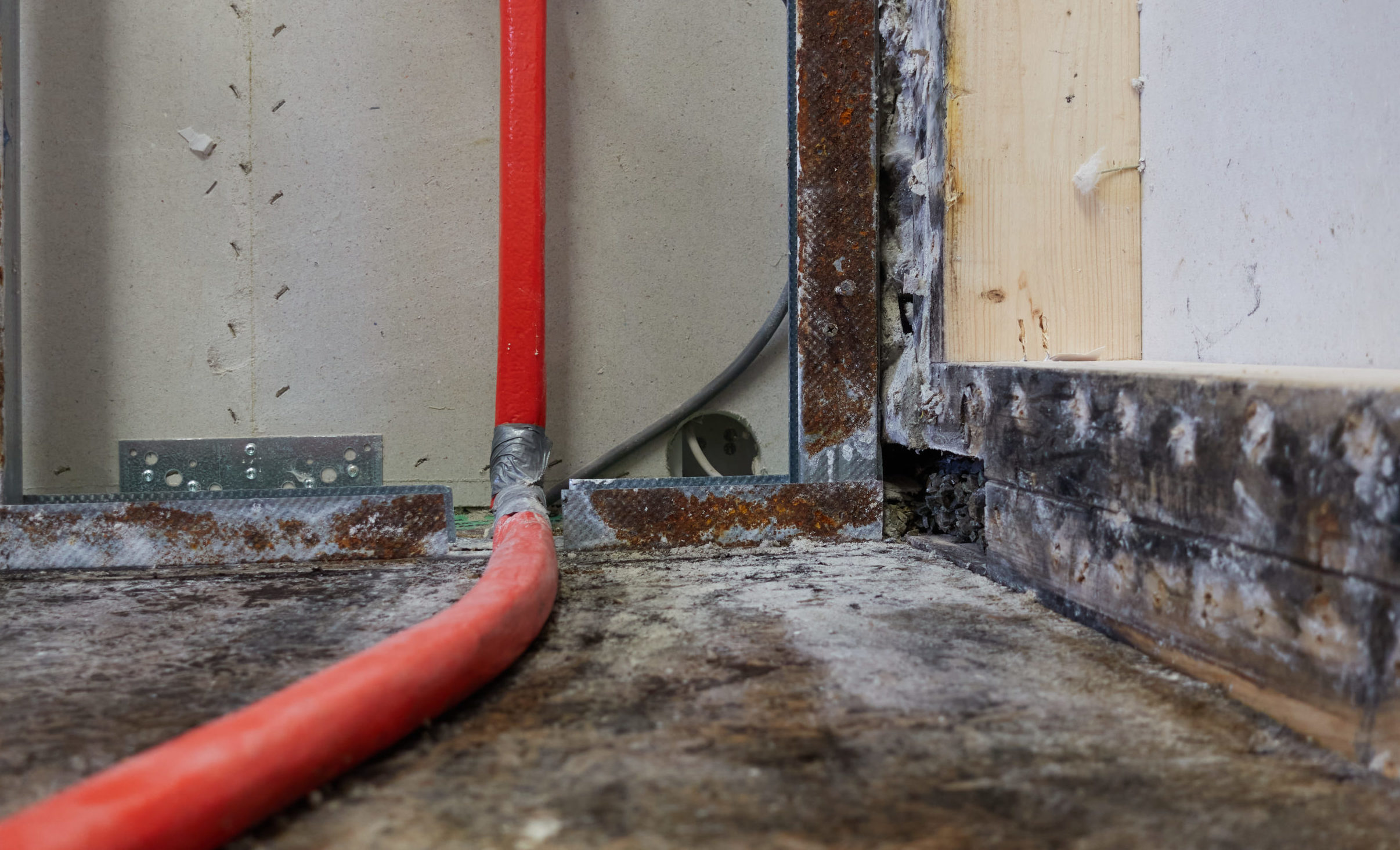 A red pipe is connected to the wall.