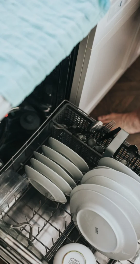 A person loading dishes into the dishwasher.